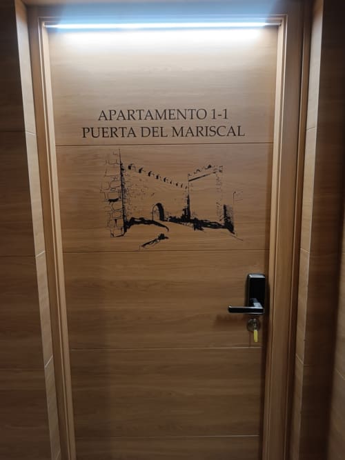 Puerta del apartamento 1-1 en Apartamentos Turísticos Ávila con croquis arquitectónico de la Puerta del Mariscal