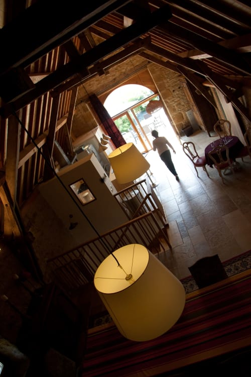 Vue aérienne du gîte Source de Manon aux Pratges B&B à Figeac avec poutres apparentes, lampes jaunes et entrée lumineuse