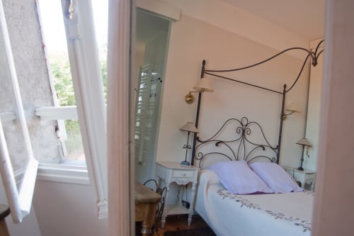 Chambre Manon aux Chambres d'hôtes Les Pratges à Figeac, avec lit en fer forgé et vue sur le jardin