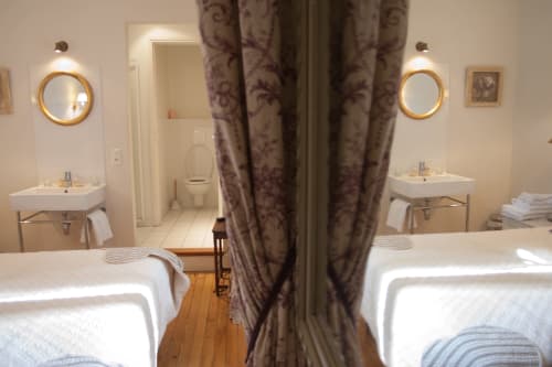 Lits jumeaux à la Chambre Lalie des Pratges B&B Figeac, avec salles de bains privées et rideaux ornés