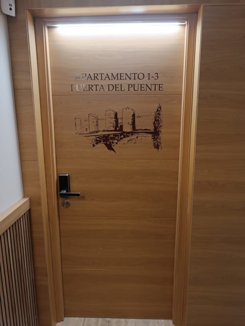 Puerta de madera del Apartamento 1-3 Puerta del Puente en el hotel Ávila con grabado de bosquejo arquitectónico