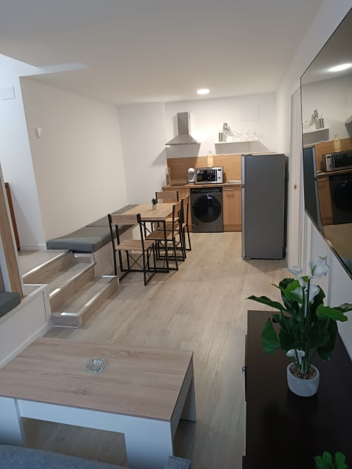 Cocina y comedor moderno en Apartamentos Turísticos Ávila con electrodomésticos de acero inoxidable y vista a la ciudad