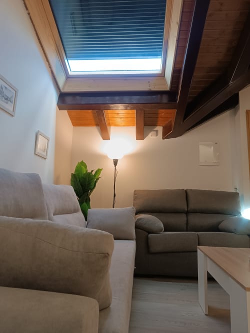 Moderno salón en Ávila con cómodos asientos, tragaluz y abundante luz natural