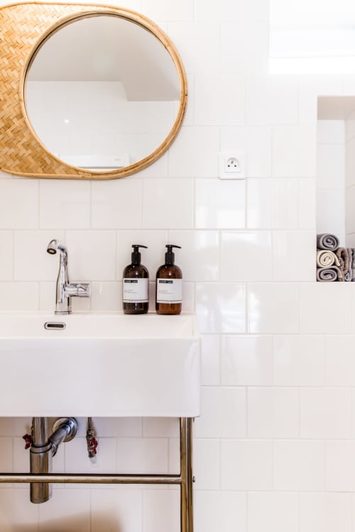 Lavabo moderne avec miroir tressé et carrelage blanc métro à l'hôtel cottage Les Filles du Bord de Mer à Port-en-Bessin