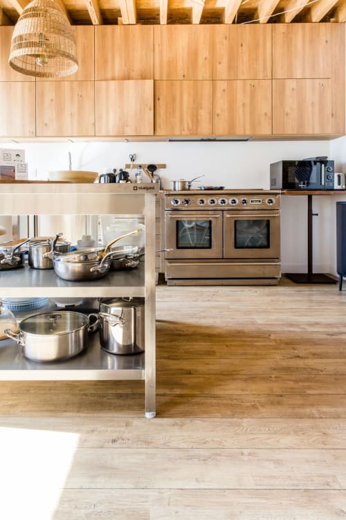 Cuisine moderne du gîte Les Filles du Bord de Mer avec armoires en bois, fours doubles, ustensiles inox et espace ouvert