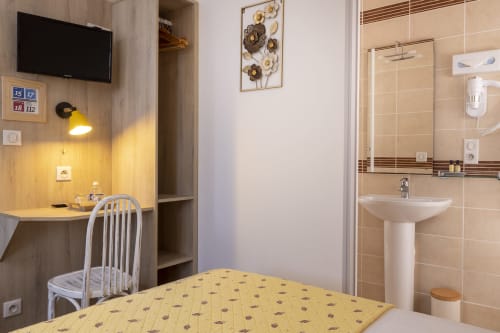 Chambre simple standard à l'Hôtel De Lion Sur Mer avec lit, bureau, salle de bains et équipements modernes