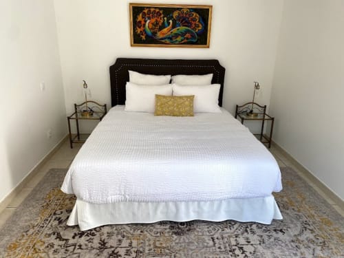 Elegant eingerichtetes Schlafzimmer im Domaine de Bize mit weißer Bettwäsche, schwarzem Kopfteil und Pfauenkunst