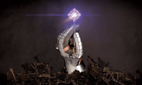 Ornate gauntlet holding glowing orb above medieval artifacts at Domaine de Bize Mirepoix