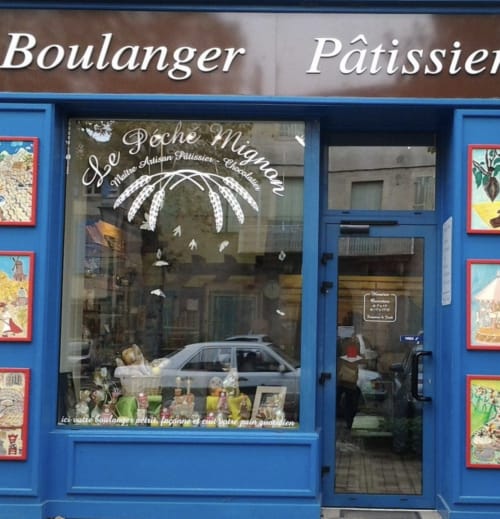 Fachada de la panadería Le Péché Mignon en Mirepoix con frente azul y vitrina de pasteles