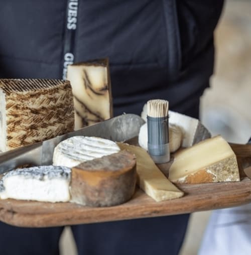 Tabla artesanal de quesos del Domaine de Bize, mostrando diversas variedades francesas en bandeja de madera en Mirepoix