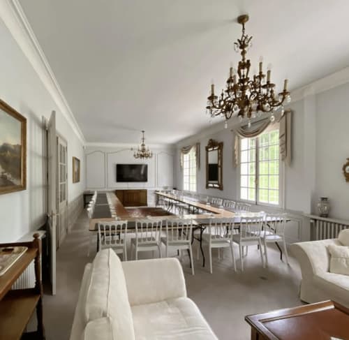 Salle à manger élégante avec lustres en cristal, chaises blanches et décor raffiné au Domaine de Bize Mirepoix, Ariège.