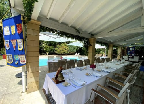 Espace de restauration en plein air à la Domaine de Bize Mirepoix, tables élégamment dressées sous une pergola couverte