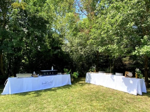 Mise en place d'événement en plein air avec tables drapées de blanc sous les arbres au Domaine de Bize, un manoir français à Mirepoix, Ariège