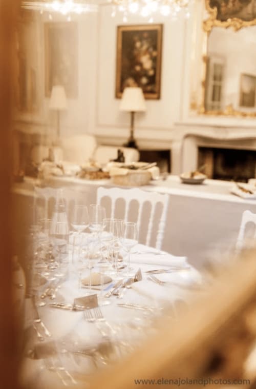 Elegantes Esszimmer im Domaine de Bize Mirepoix mit formal gedecktem Tisch, Kristallgläsern und Kamin in der Ariège.
