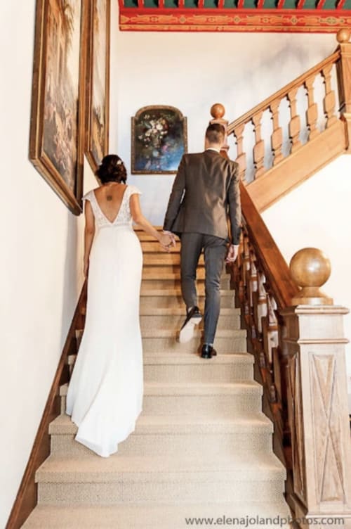 Couple montant l'escalier en bois d'un élégant manoir au domaine de Bize, lieu de mariage à Mirepoix Ariège