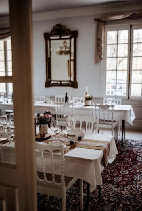 Elegantes Esszimmer in der Domaine de Bize mit gedeckten Tischen, Stühlen und dekorativem Spiegel in Mirepoix