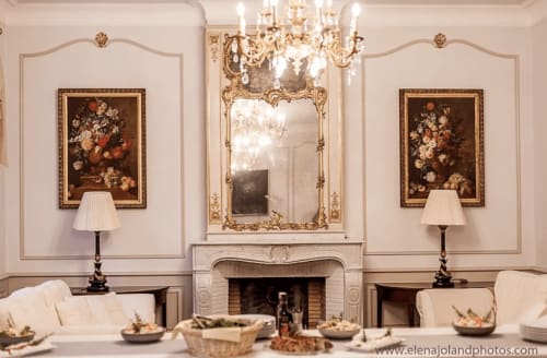 Elegantes Kaminzimmer im Domaine de Bize mit Blumengemälden, verziertem Spiegel und Kronleuchter in Mirepoix