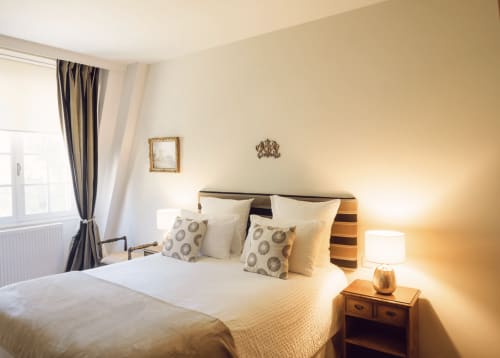 Elegant bedroom at Domaine de Bize in Mirepoix with queen bed, warm lighting, and classic French decor