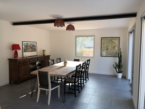 Modern dining room at La Conciergerie Biarritz with wooden table, black chairs, and coastal views