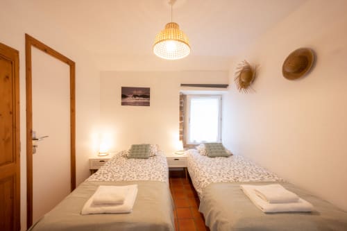 Twin bedroom at Espace Ker Gana B&B in Plourin with two single beds, wooden beams, pendant light, and coastal decor