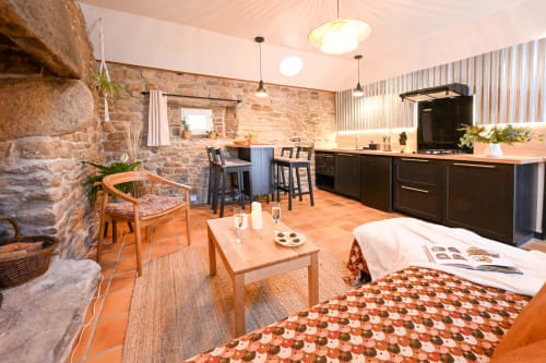 Open-plan kitchen and living area at Maison Aster, Espace Ker Gana B&B in Plourin with stone walls and modern furnishings