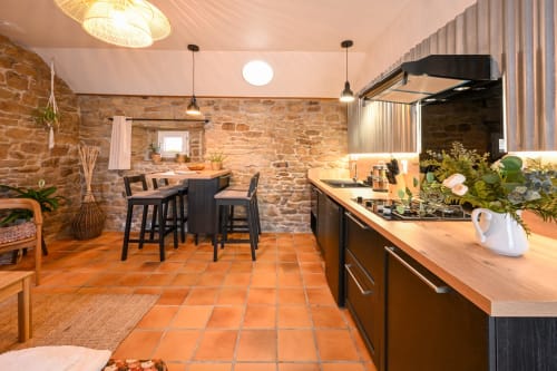 Modern kitchen and dining area in Maison Aster at Espace Ker Gana, Plourin, with stone walls and terracotta floors