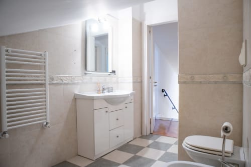Bagno moderno di Villa Il melograno a Bari con vanità bianca, scaldasalviette e pavimento piastrellato