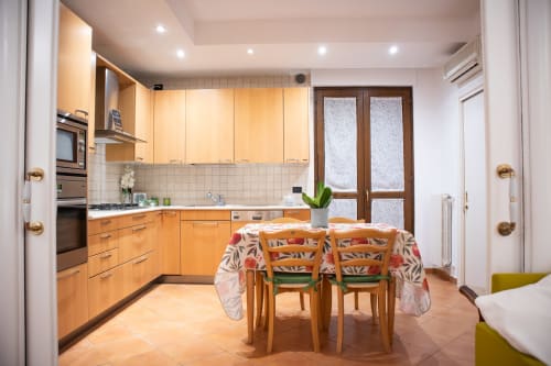 Cucina moderna con arredamento in legno e zona pranzo a Villa Il melograno, affittacamere con vista sul giardino a Bari