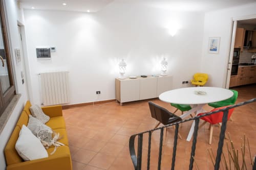 Zona living open-plan moderna in villa a Bari con divano giallo, tavolo da pranzo e arredi contemporanei