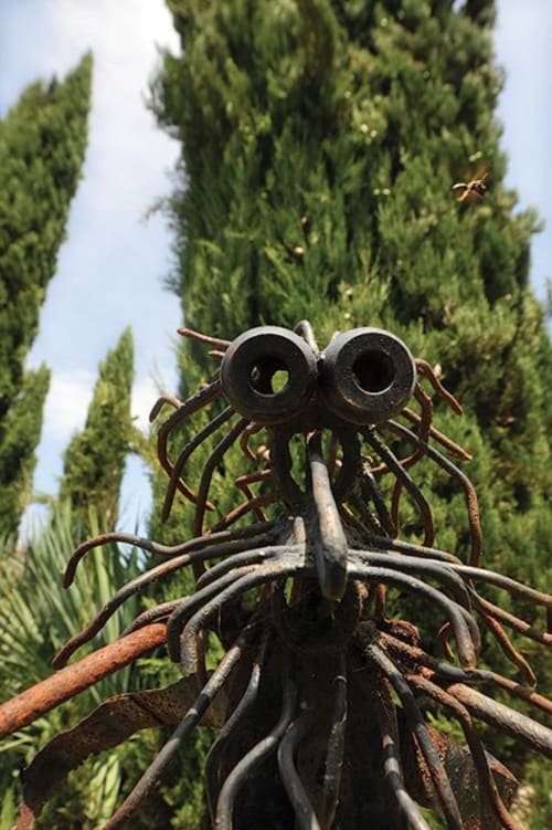 Handmade recycled metal art adding character to the garden of a traditional Tuscan agriturismo