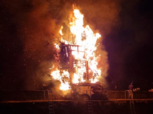 Bonfire event at Villa Vista Lago di Como in Bellano, Italy with flames and wooden structure at night