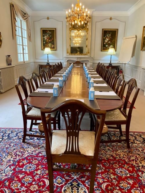 Élégante salle à manger formelle au Domaine de Bize avec longue table en bois, lustre en cristal et décor classique