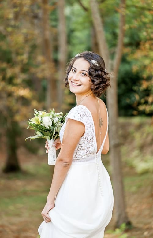 Braut im weißen Spitzenkleid mit Blumenstrauß in Waldkulisse am Domaine de Bize, Mirepoix