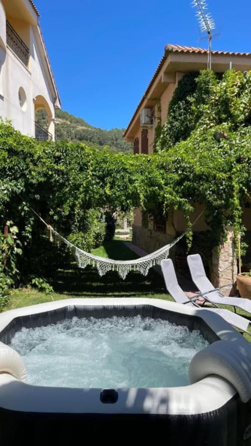 Bañera de hidromasaje con hamaca en el exuberante jardín de la Casa Rural Villa del Jerte, El Torno Cáceres