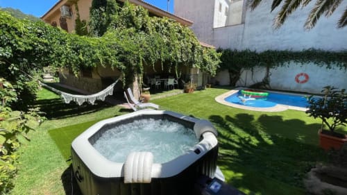 Patio de Casa Rural Villa del Jerte con jacuzzi, piscina, hamaca y jardines verdes en El Torno, Cáceres