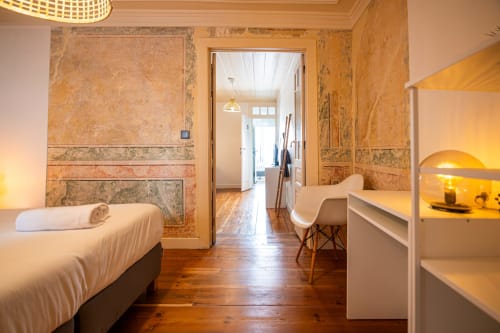 Suite Tripla Flexível no VAGO Alcântara Suites em Lisboa com cama, beliches, piso em madeira e paredes em cortiça