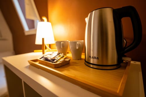 Comodidades da suíte do hotel: chaleira elétrica, canecas, luminária e secretária no VAGO Alcântara Suites, Lisboa