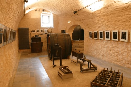 Exposition muséale d'une ancienne cave à vin aux Gîtes Des Planchettes à Marigny avec tonneaux en bois et équipements d'époque