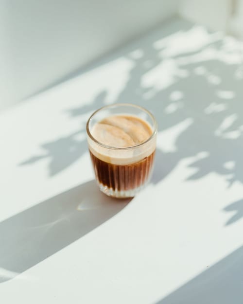 Espresso avec mousse de crema sur surface blanche avec ombres de feuilles aux Gîtes Des Planchettes, Marigny