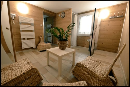 Espace de détente spa rustique aux Gîtes Des Planchettes à Marigny avec fauteuils en osier, plantes en pot et éclairage chaleureux