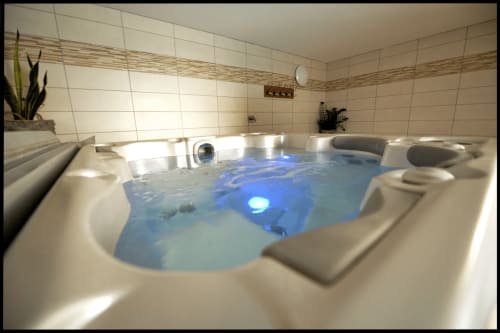Baignoire de luxe avec éclairage bleu dans une salle de bain moderne aux Gîtes Des Planchettes, Marigny