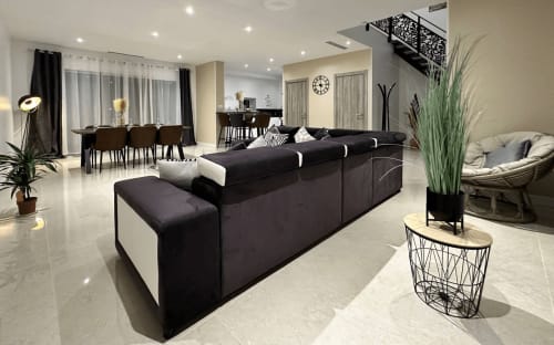 Salon moderne ouvert aux Gîtes Les Camélias 71 à Oslon avec canapé sectionnel noir et mobilier élégant