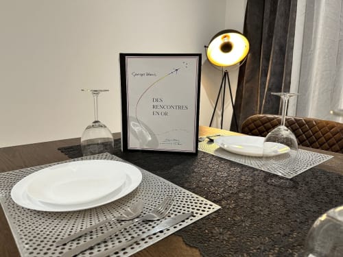 Élégante mise en place aux Gites Les Camelias 71 à Oslon : assiettes blanches, verres et lampe de bureau moderne.