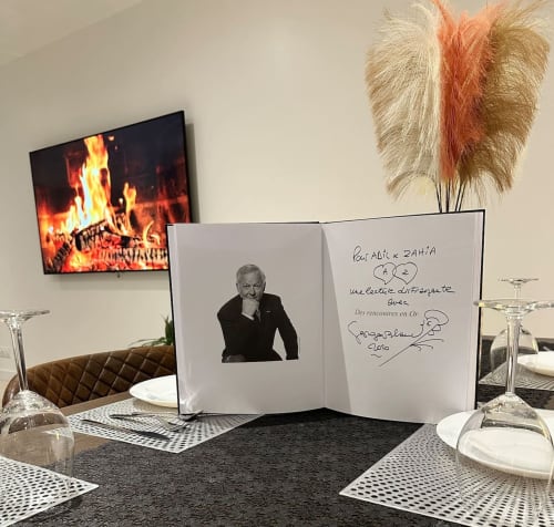 Table de fine dining aux Gîtes Les Camelias 71 avec livre dédicacé et cheminée