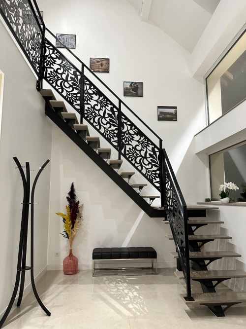 Escalier moderne avec rampe noire ornementale aux Gîtes Les Camélias 71, chambres d'hôtes à Oslon, France