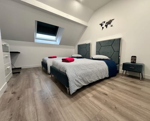 Chambre moderne aux Gîtes Les Camelias 71 à Oslon avec lits jumeaux, têtes de lit sombres et velux