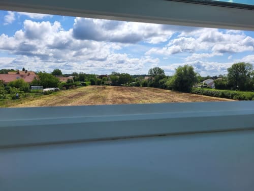 Vue sur la campagne rurale depuis les Gîtes Les Camelias 71 à Oslon, France, avec champs labourés et fermes