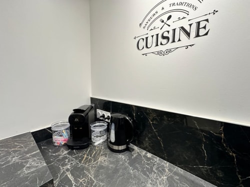 Comptoir de kitchenette en marbre noir avec cafetière, bouilloire et verres aux Gîtes Les Camélias 71 à Oslon, France