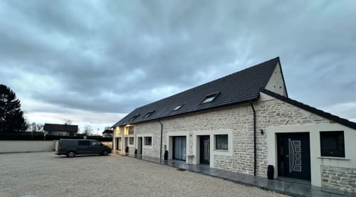 Gîtes Les Camélias 71, chambres d'hôtes à Oslon en France - bâtiment en pierre avec toit sombre et parking au crépuscule