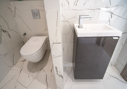 Salle de bains moderne aux Gîtes Les Camelias 71 avec carrelage effet marbre, toilettes suspendues et vasque compacte à Oslon